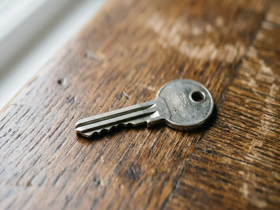 Plain metal car ignition key on a wooden table