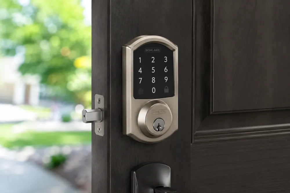 Satin nickel touchscreen keypad smart deadbolt with key cylinder on a dark wood front door